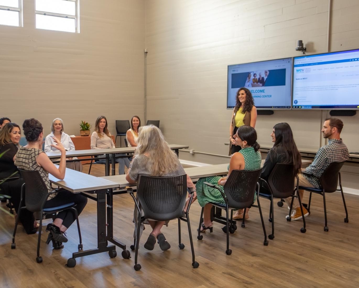 Staff member Irene Kelly leads a group discussion on women's empowerment in WEV's Community Room.