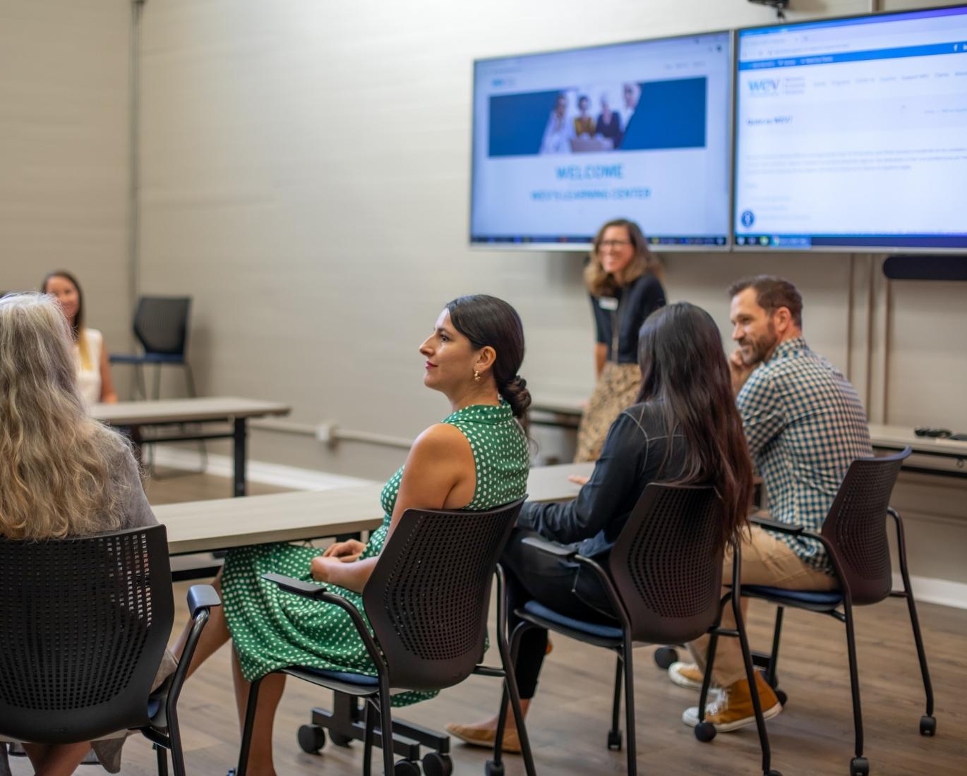 Lili Munoz and other community members learn about WEV's Women's Business Center in the SB Community Room.