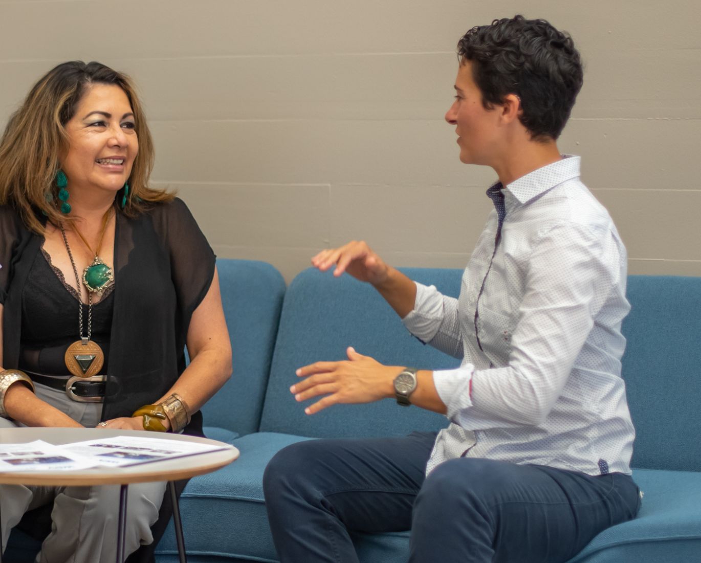 Propietarias de negocios sentados juntos en una mesa, discutiendo sus experiencias y estrategias comerciales.